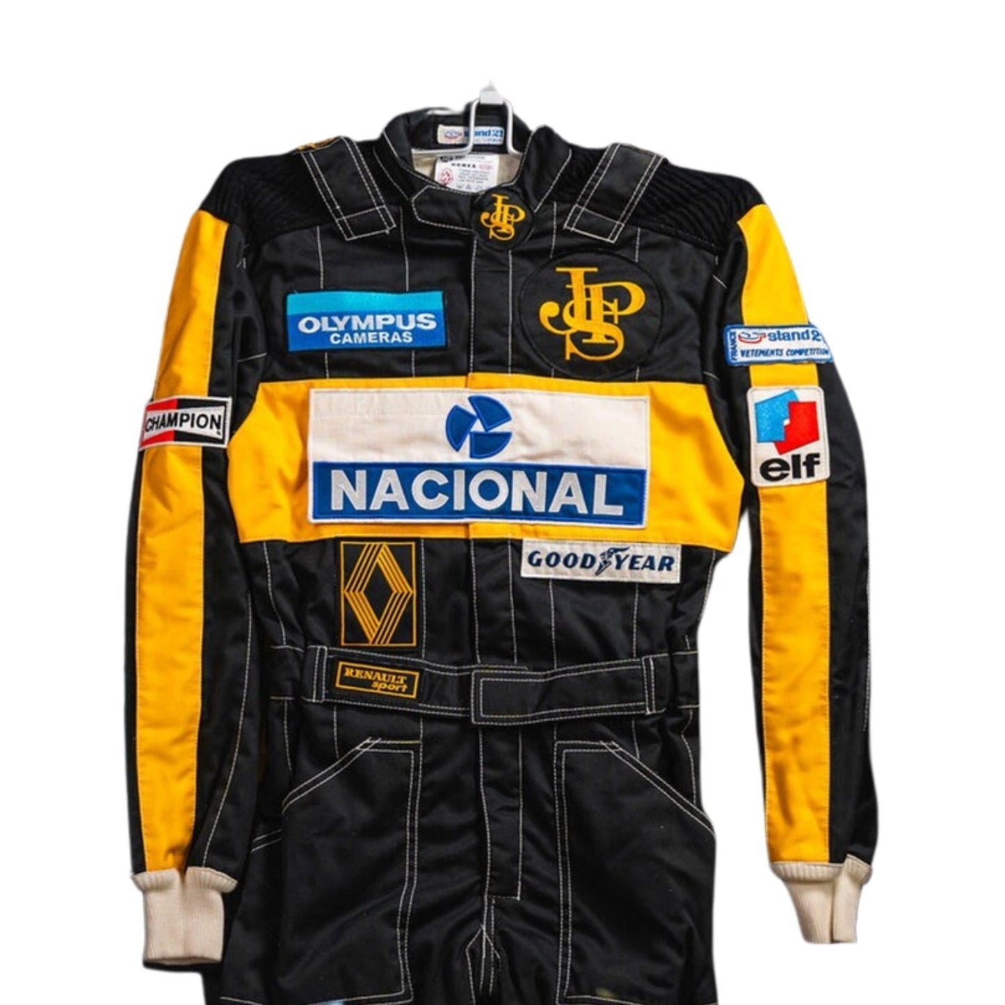 Close-up detail of the Ayrton Senna 1985 F1 racing suit fabric and stitching, showcasing vintage craftsmanship and sponsor detailing.