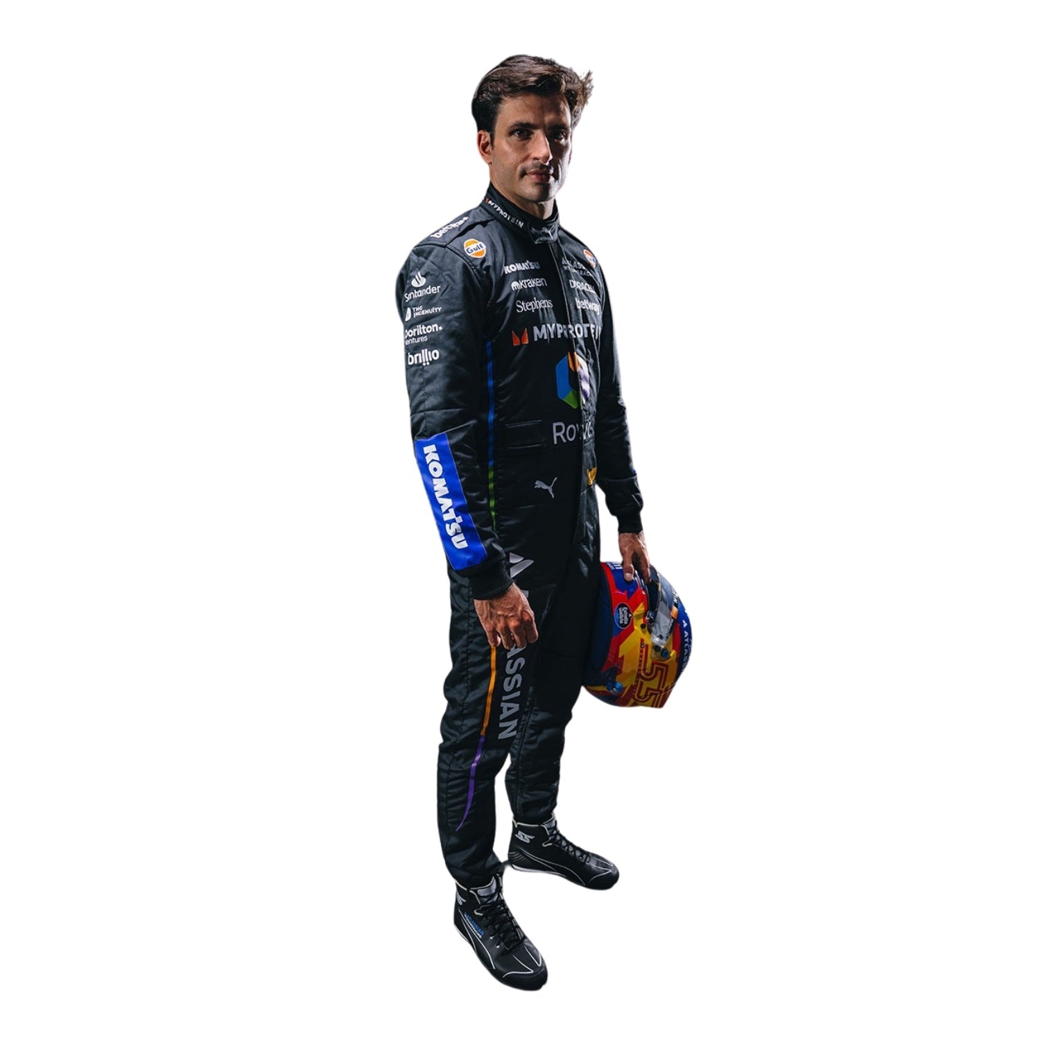 Carrlos Sainz wearing a racing suit holding a helmet on a white background