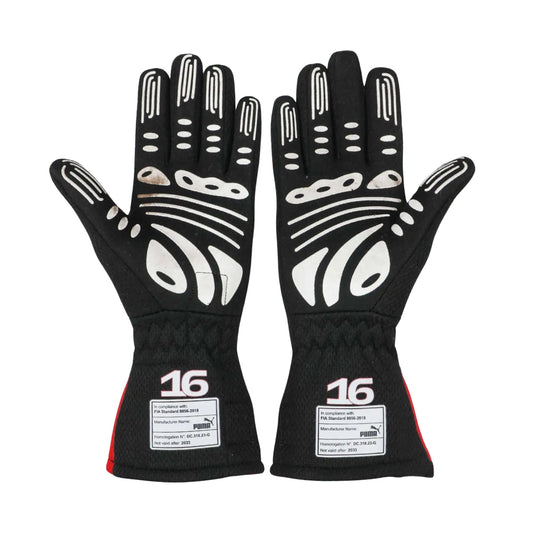 Pair of black Charles Leclerc 2023 F1 race gloves with white accents and '16' branding on a white background