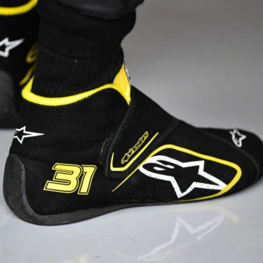 Black and yellow Esteban Ocon 2020 Tuscan GP F1 Race shoe cover with number 31 and star logo on a gray background