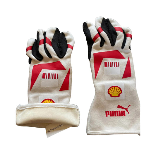 Pair of white Michael Schumacher 2007 F1 race gloves with red and black accents featuring Puma and Shell logos on a white background.