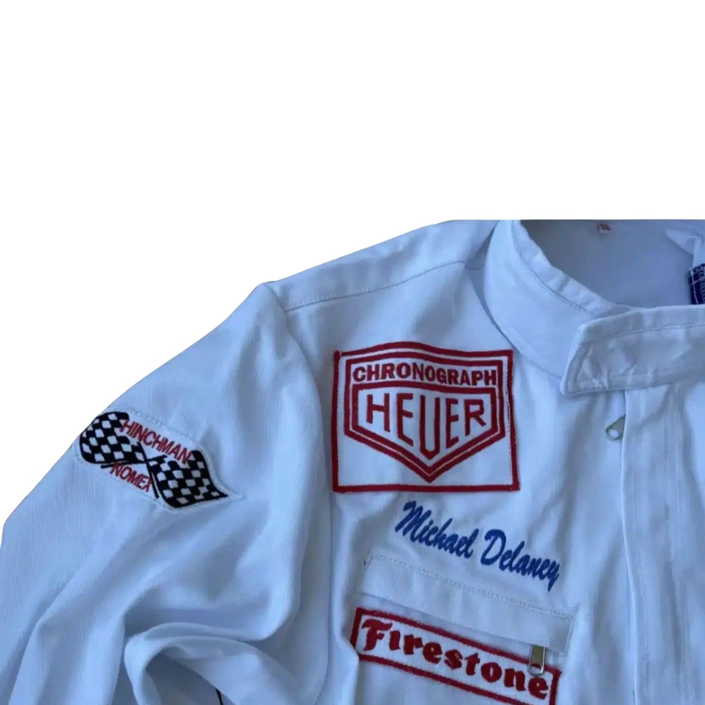Close-up of the Gulf and Heuer logo patches, stitching detail, and authentic period-correct fabric from the 1971 Le Mans suit worn by Steve McQueen.