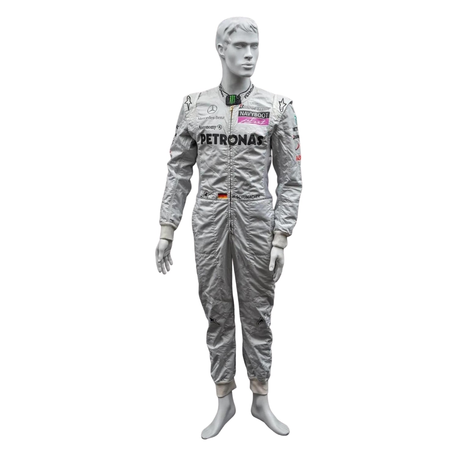 Front view of Michael Schumacher’s 2010 F1 racing suit in silver with green and black accents, featuring signature branding and structured design.