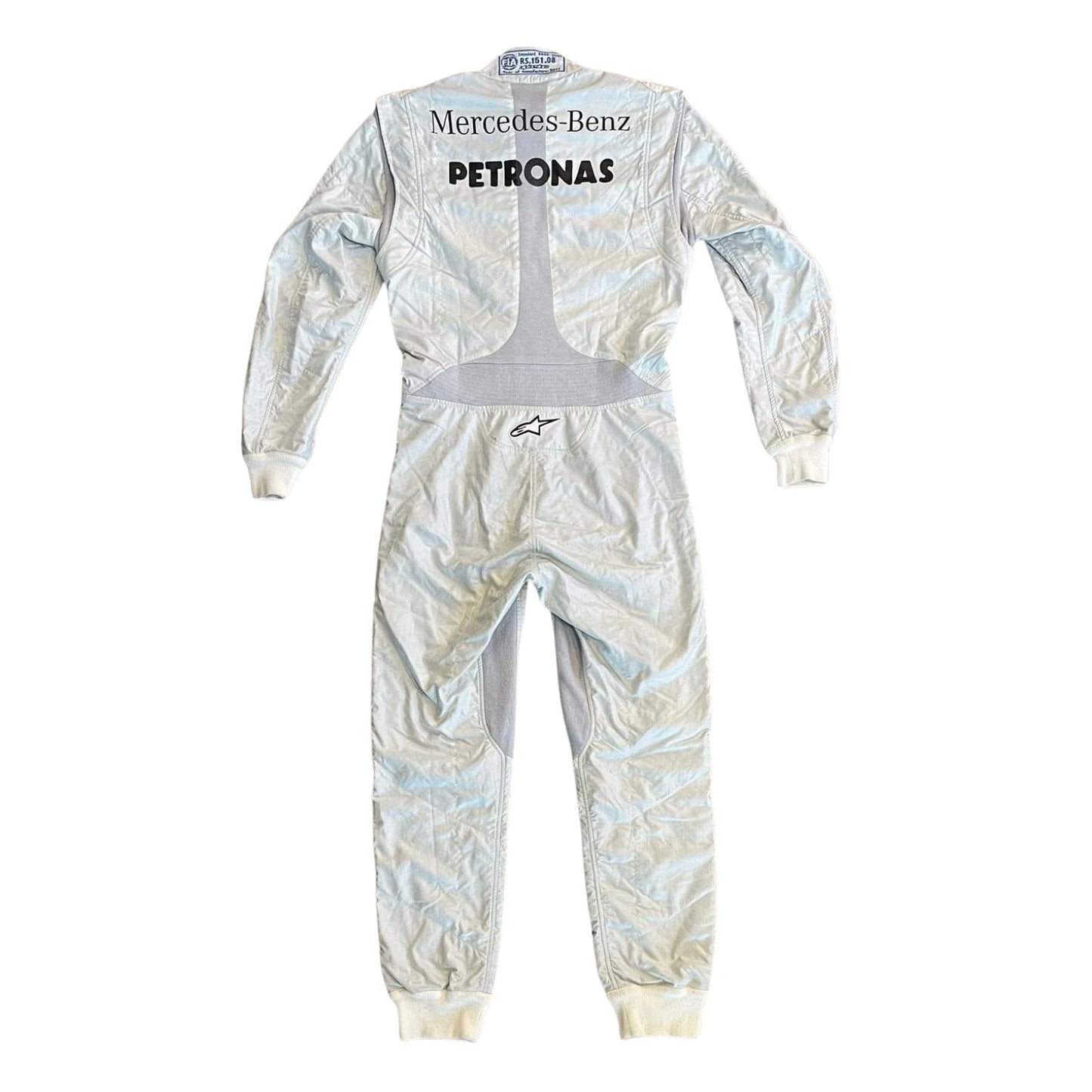 Rear view of Schumacher’s 2011 race suit with full silver finish, featuring name embroidery and aerodynamic panel construction.
