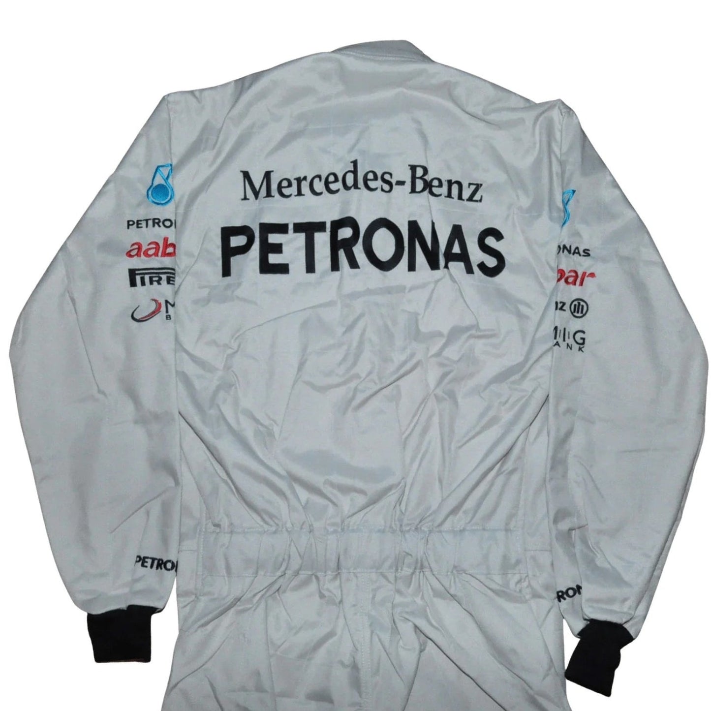 Back view of Schumacher’s 2012 F1 suit showing full-length silver material with contrasting black paneling and his signature logo on the upper back.