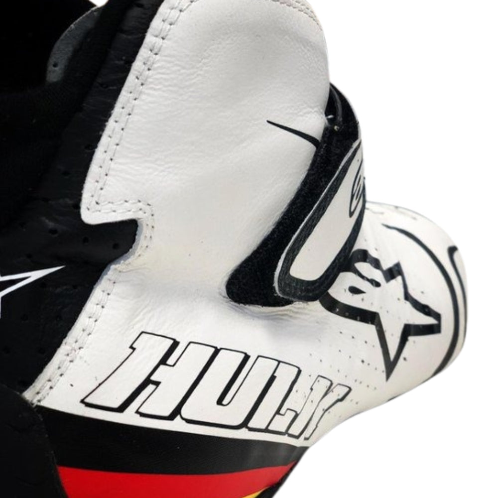 Close-up of a white Nico Hülkenberg 2019 F1 racing shoes with black and red accents, featuring a logo and text.