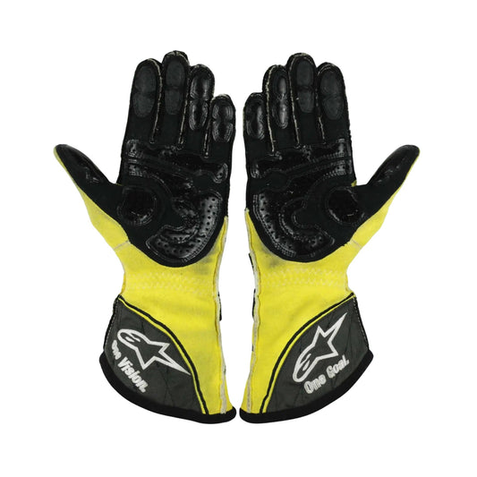 Pair of black and yellow Nico Rosberg 2011 F1 race gloves with a brand logo on a white background