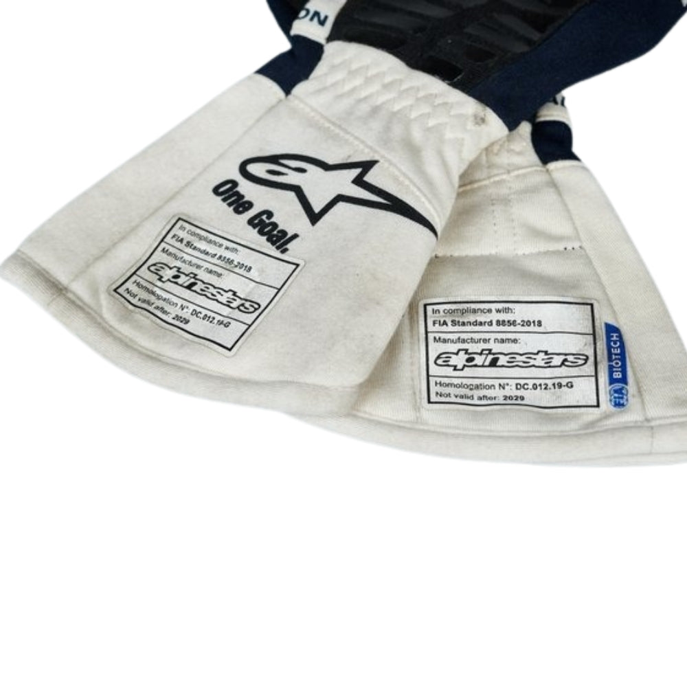 Close-up of a white Yuki Tsunoda 2022 F1 Race gloves with visible branding on a white background