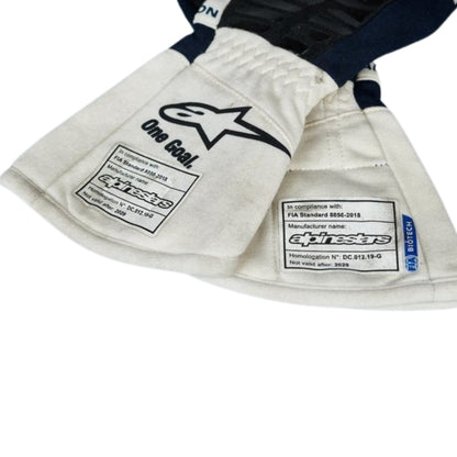 Close-up of a white Yuki Tsunoda 2022 F1 Race gloves with visible branding on a white background