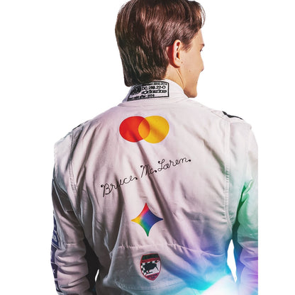 oscar piastri wearing a white racing suit with multiple sponsor logos against a plain white background.